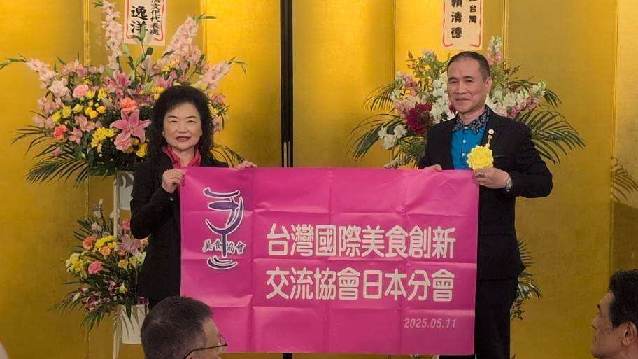 台湾総会総会長の何淑子氏が、日本支部の旗を日本支部副理事長の鄭文龍氏に手渡した